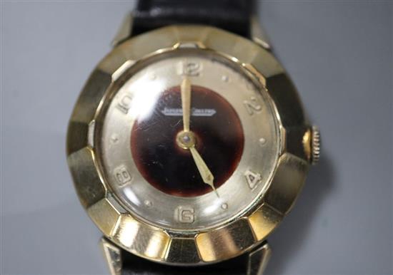 A gentlemans 10k gold filled Jaeger Le Coultre manual wind wrist watch, with panelled bezel, on a leather strap.